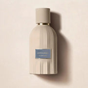 Beige perfume bottle with a blue label on a beige background